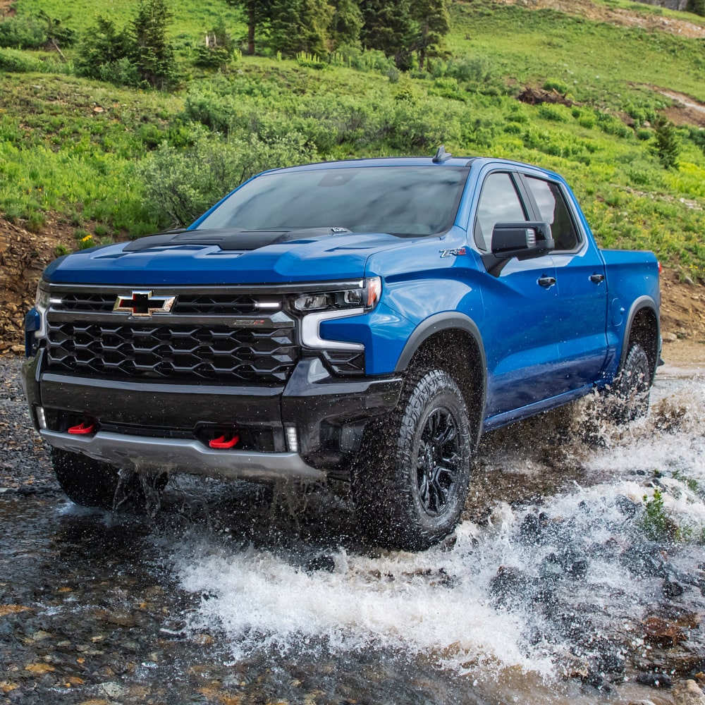 Chevrolet Silverado color azul atravesando un rio.
