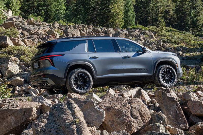 Vista lateral de Chevrolet Traverse cruzando un camino de piedras.