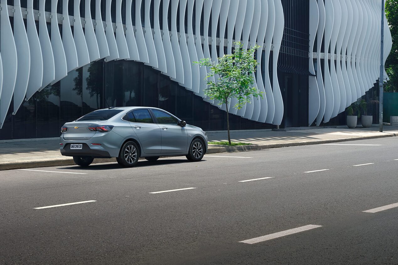 Vista lateral trasera del Chevrolet Onix Plus estacionado en área urbana