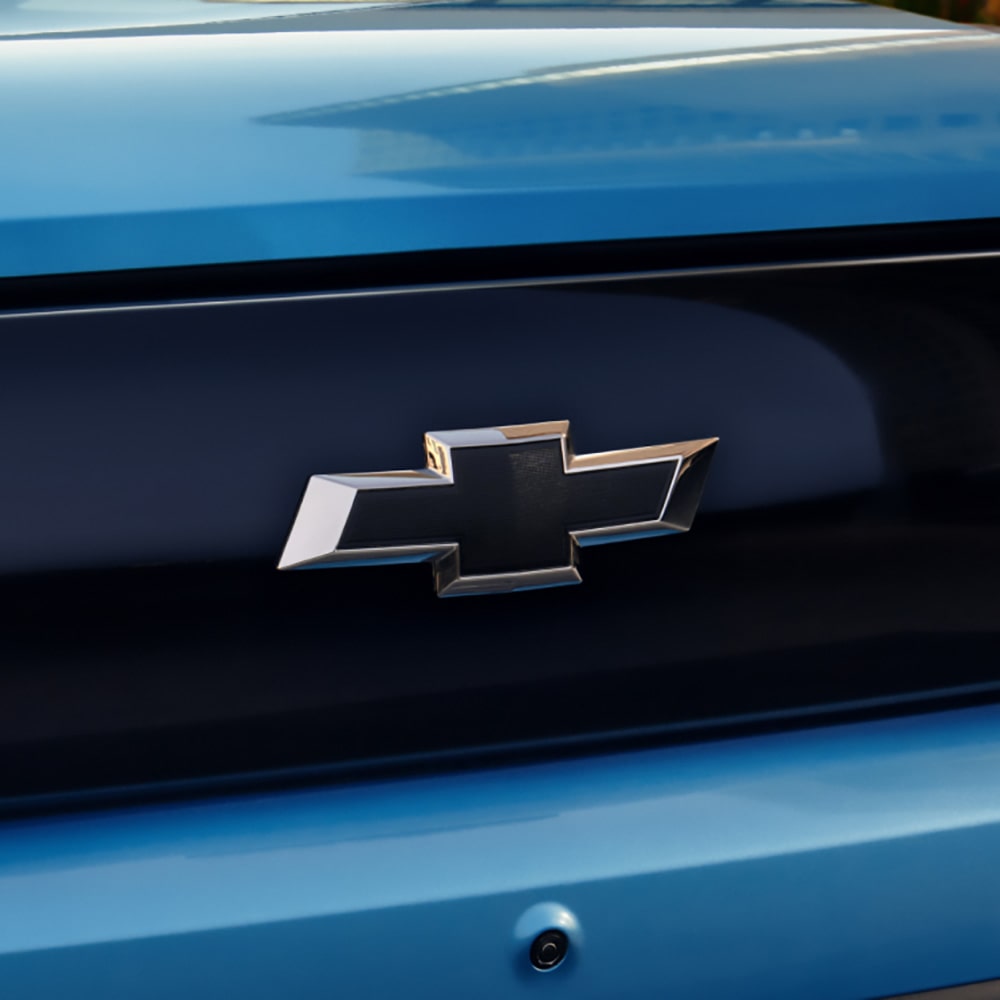 Emblema Chevrolet destacado sobre carrocería azul, símbolo de calidad y confianza