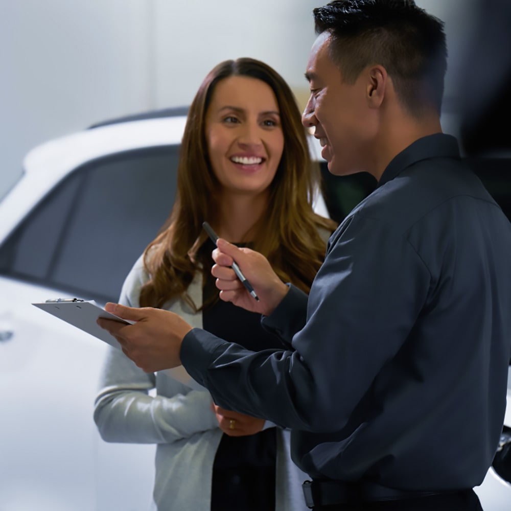 Asesor Chevrolet brindando atención personalizada a cliente satisfecha en concesionario