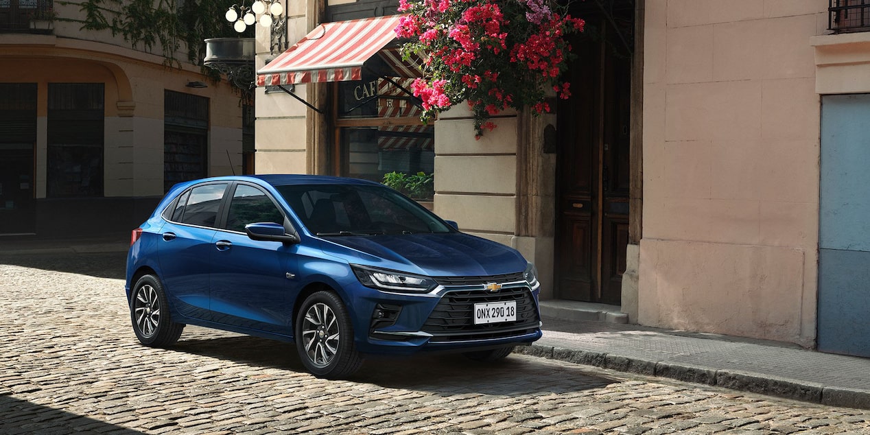 Vista lateral frontal del Chevrolet Onix 2026 color Azul Some Kinda Blue estacionado en zona urbana 