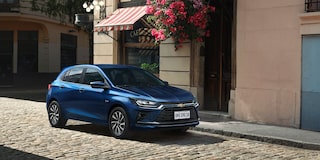 Vista lateral frontal del Chevrolet Onix 2026 color Azul Some Kinda Blue estacionado en zona urbana