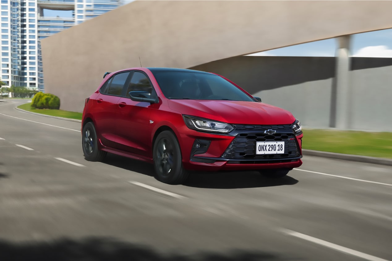 Chevrolet Onix 2026 color Rojo Jinx conduciendo en ruta urbana