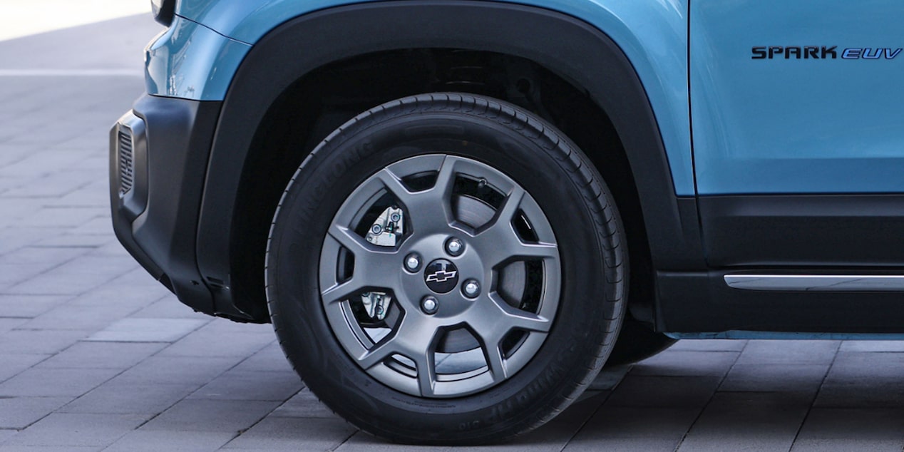 Detalle lateral de la llanta del Chevrolet Spark EUV 2025 en color azul, destacando diseño robusto y urbano