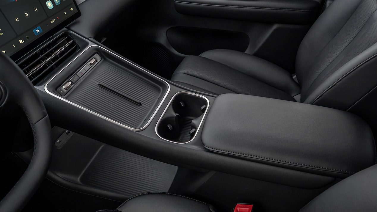 Vista interior de de la Chevrolet Captiva EV, destacando pantalla táctil, portavasos doble y apoyabrazos acolchado.