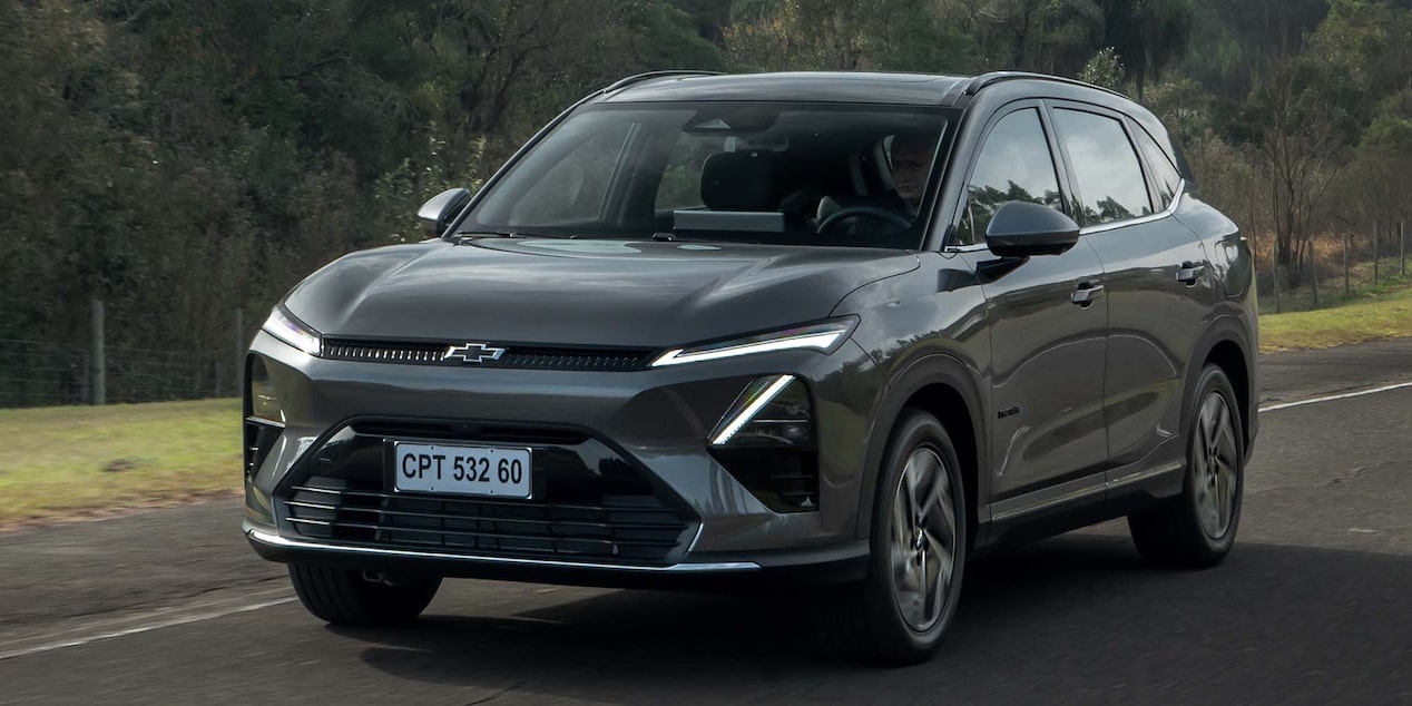 Vista frontal de la Chevrolet Captiva EV circulando por una carretera con vegetación de fondo.